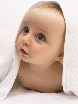 Baby bestaunt die Welt unter einem Handtuch