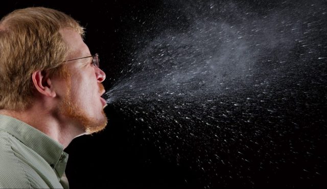 Mann niest bei Grippe