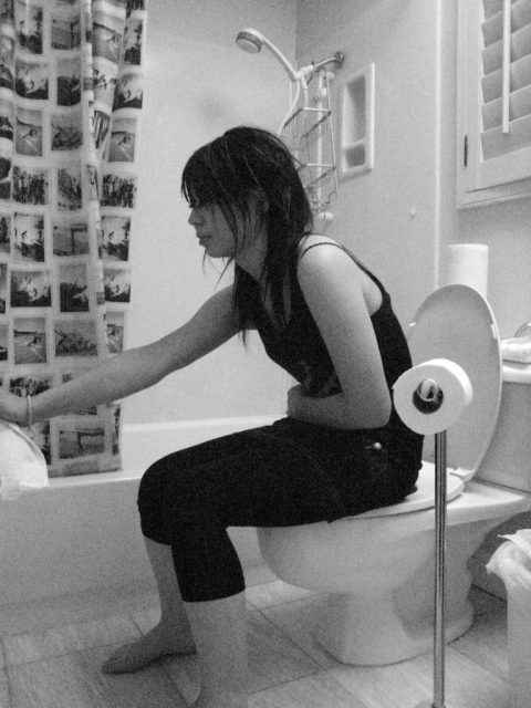 Mädchen sitzt mit Verstopfung auf Toilette