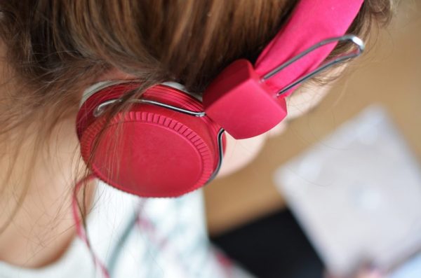Tinnitus durch zu laute Musik? Mädchen mit rosafarbenen Kopfhörern