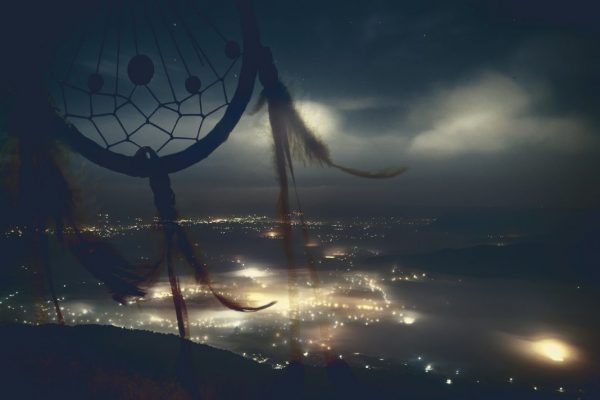 Traumfänger und Stadt bei Nacht im Hintergrund