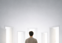 Wenn Freiheit dich müde macht: Das Paradox der Wahl im Alltag Person steht in hellem Raum vor mehreren offenen Türen und kann sich nicht entscheiden